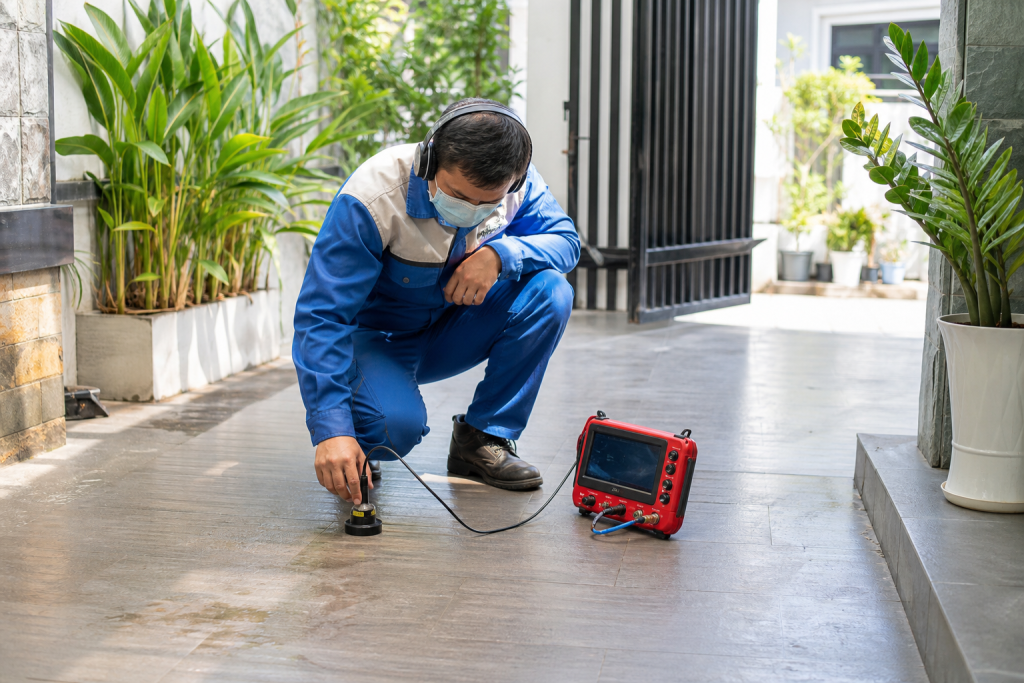Kỹ thuật viên đang dò tìm ống nước bể ngầm bị rò rỉ tại một ngôi nhà ở Nha Trang